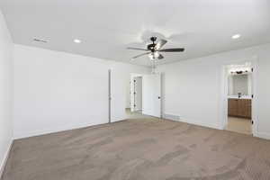 Unfurnished bedroom with recessed lighting, carpet flooring, a ceiling fan, and ensuite bath