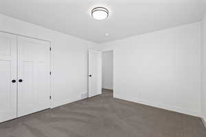 Unfurnished bedroom with carpet flooring and a closet