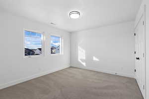 Unfurnished room with carpet flooring and baseboards