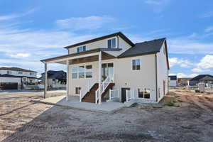 Back of property with a patio area and a shingled roof