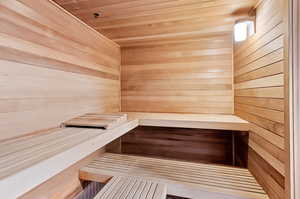 Relaxing sauna featuring wood ceiling and wood walls