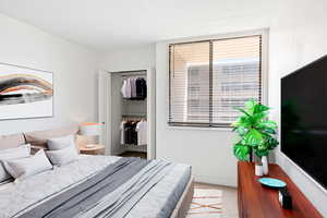 Bedroom with light colored carpet and a closet