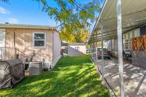 View of grassy yard with oil tank, a sunroom, and a shed