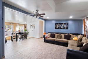 Living area featuring tile patterned flooring, a ceiling fan, a textured ceiling, and recessed lighting