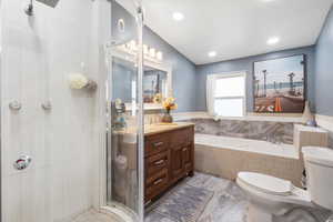 Bathroom featuring vanity, a bath, a shower stall, and recessed lighting