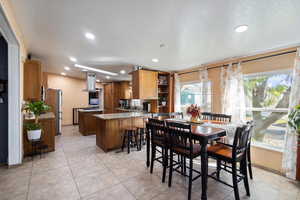 Dining space featuring recessed lighting, a textured ceiling, and light tile patterned flooring