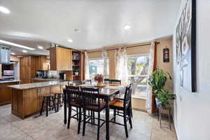 Dining area with recessed lighting, a textured ceiling, and light tile patterned floors