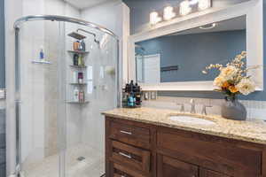 Full bath featuring vanity and a stall shower