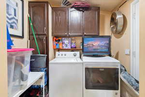 Washroom with washing machine and clothes dryer and cabinet space