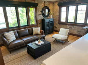 Living room featuring light wood-style floors and brick wall