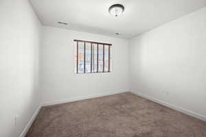 3rd bedroom with carpet and natural light.