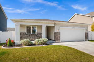 Craftsman-style home with stone siding, an attached garage, concrete driveway, a gate, and covered porch