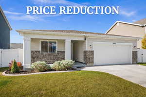 View of front of property with a gate, stone siding, a garage, and driveway