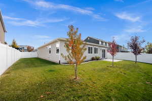 Back of house featuring a fenced backyard, a patio and trees.