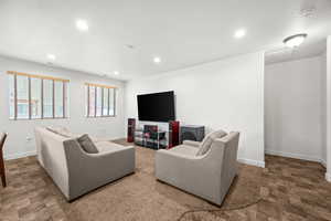 Living area featuring recessed lighting and large windows.