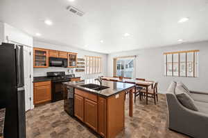 Kitchen featuring black appliances, quartz countertop, and wood cabinetry.
