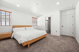 Bedroom featuring multiple windows, carpet flooring, ensuite bathroom, and recessed lighting