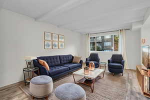 Living area with wood finished floors and beamed ceiling