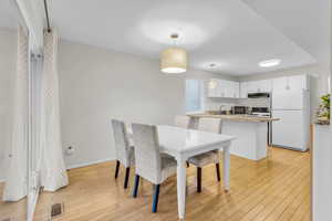 Dining area with baseboards and light wood-type flooring