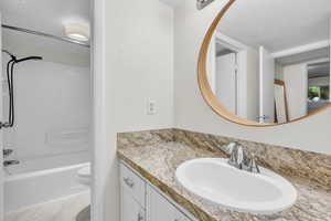 Full bathroom with shower / washtub combination and vanity