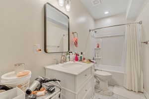 Bathroom featuring shower / bath combo, vanity, light marble finish flooring, and recessed lighting