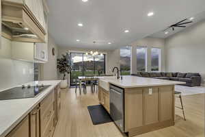 Kitchen featuring recessed lighting, light wood-style floors, open floor plan, a chandelier, and custom range hood