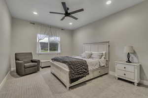 Bedroom with light colored carpet, ceiling fan, and recessed lighting