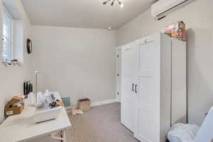 Office space with light carpet and a wall mounted AC