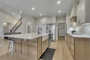 Kitchen featuring recessed lighting, light brown cabinets, light wood-style flooring, a spacious island, and appliances with stainless steel finishes