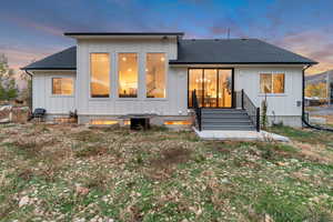 Back of house with roof with shingles and board and batten siding