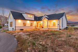 Modern farmhouse style home featuring board and batten siding, covered porch, and roof with shingles