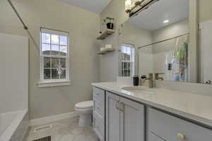 Full bath featuring vanity, plenty of natural light, light tile patterned flooring, and shower / tub combo with curtain