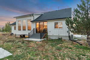 View of front of house featuring board and batten siding and roof with shingles