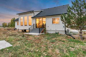 Modern inspired farmhouse featuring board and batten siding and a shingled roof