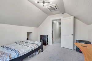 Bedroom with cooling unit, light colored carpet, a textured ceiling, and lofted ceiling