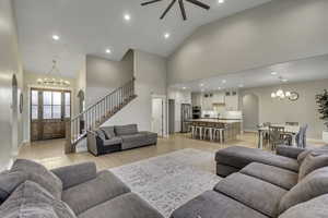 Living room featuring a chandelier, arched walkways, recessed lighting, stairway, and light wood-style flooring
