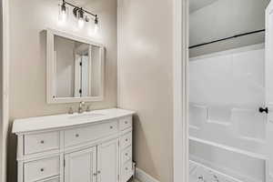 Bathroom featuring vanity and shower / washtub combination