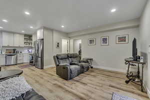 Living area with recessed lighting and light wood-type flooring