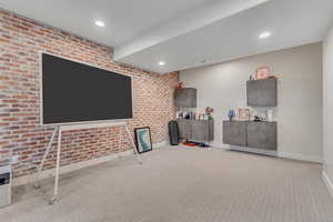 Playroom with brick wall, carpet, and recessed lighting
