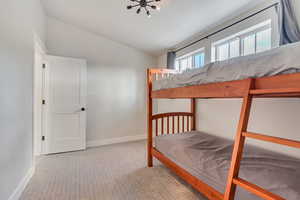 Bedroom featuring light carpet and lofted ceiling