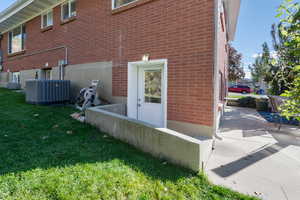 View of side of home featuring a cooling unit and basement entrance