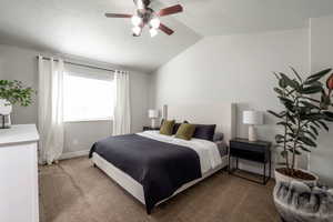 Carpeted bedroom with vaulted ceiling, a ceiling fan, and a textured ceiling
