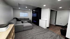 2nd Living area featuring a modern, electric fireplace, textured ceiling, wood finished floors, and recessed lighting