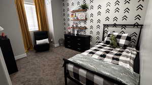 Bedroom featuring dark colored carpet and baseboards