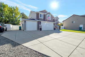 View of side of property with concrete driveway, a gate, and a garage and RV parking