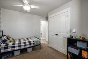 Bedroom with carpet, a closet, and ceiling fan
