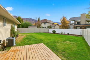Fenced backyard featuring a deck with mountain view and a residential view