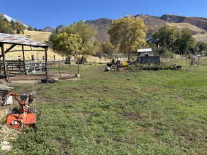 View of yard with a rural view, a mountain view, an outdoor structure, and an exterior structure