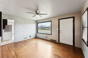 Entryway with a ceiling fan, light wood-style flooring, and a textured ceiling