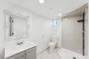 Full bath with vanity, a shower stall, light marble finish flooring, and recessed lighting